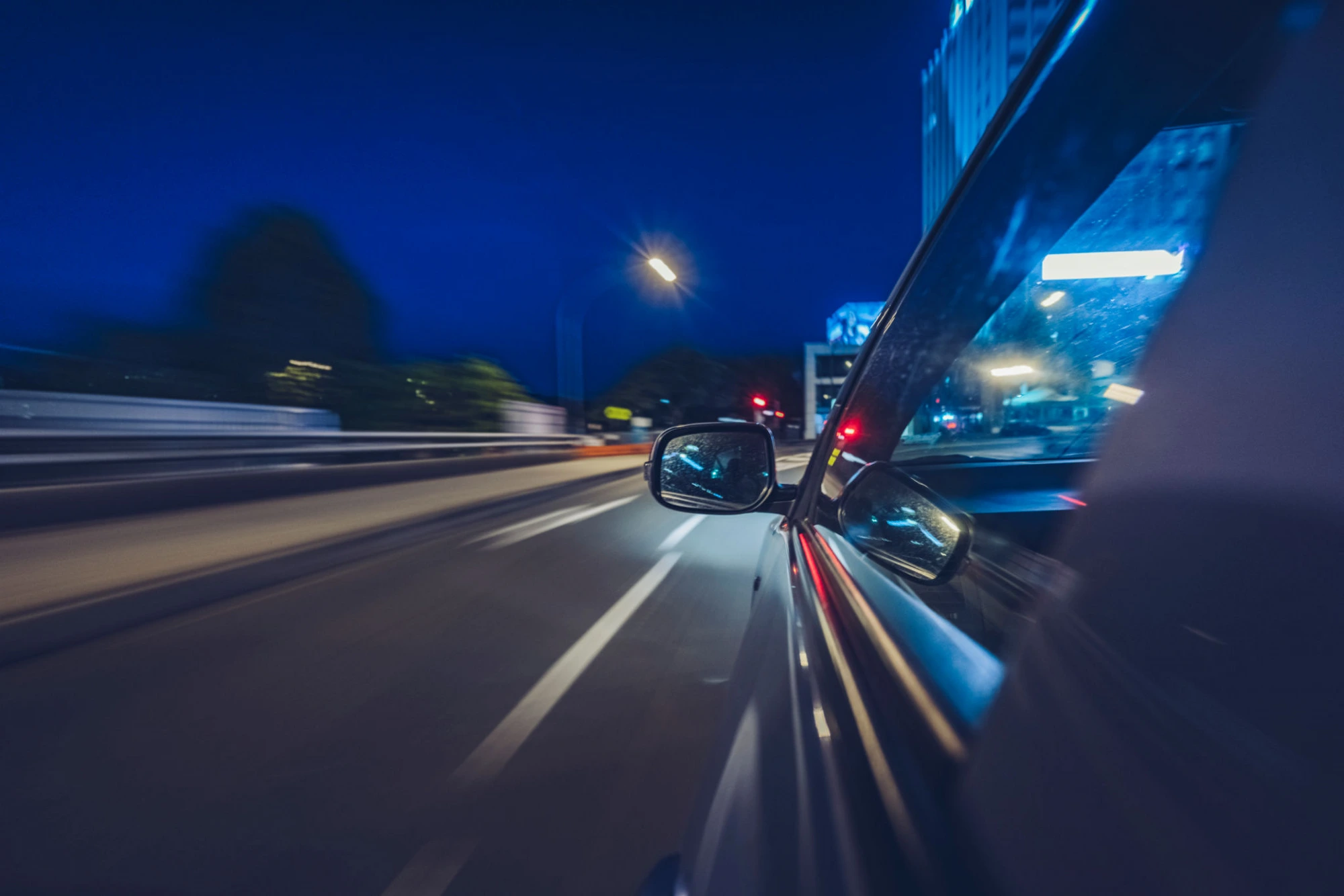 Luxury car driving at night through the city